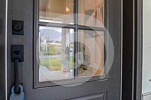 Close up of gray front door of home with glass panels black handle and keyhole