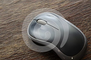 Close-up of a gray wireless computer mouse on a wooden surface