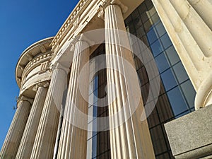 Close up of Greek style pillars and columns old fashioned style historical white architecture building with modern glass windows