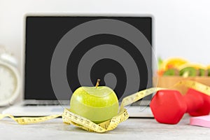 Close up green apple and tape measure. Healthy snack for diet planning for working in office.