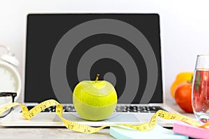 Close up green apple and tape measure. Healthy snack for diet planning for working in office.