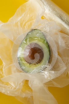 Close up green Avocado in plastic bag for sale or fridge. Effect Destroyer of the use of plastic bags. Zero waste concept. Avocado photo