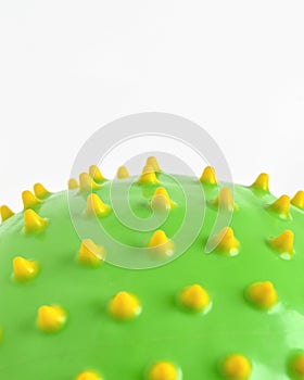 Close up of green ball with yellow spikes isolated on white background