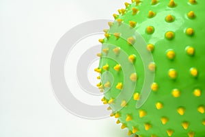 Close up of green ball with yellow spikes isolated on white background