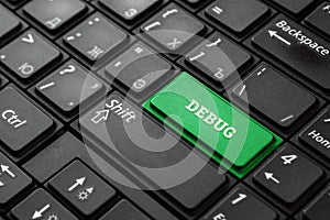 Close-up green button with the word debug, on a black keyboard. Creative background, copy space. Concept magic photo