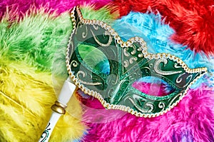 Close-up green carnival mask, venetian mask place on the colorful fluffy, Top view