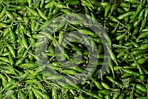 Close-up of green chillies mixed. Close up top view of freshly harvested green chillies  displayed in market for sale.