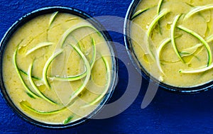 Close up of green cold zucchini soup with swirls of zucchini strips