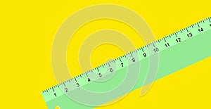 A close up of a green desk rule. Isolated element on yellow background.