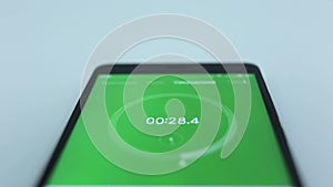 Close-up of the green of digital stopwatch with white running numbers. Stopwatch on the smartphone