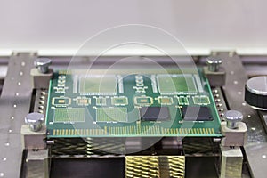 Close up green electronic printed circuit board pcb for computer or equipment setup on jig at work table