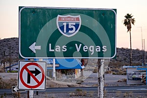 CLOSE UP: Green highway sign directs traffic across Mojave desert to Las Vegas.