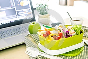 Close up green Lunch box on the work place of working desk ,Healthy eating clean food habits for diet and health care concept