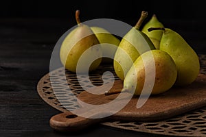 Close-up of green pears on wooden planks and table, selective focus