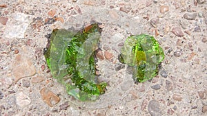 Close up green picture about crystal protoplasm with emerald color on the background of sand and gravel, crystallization alien bio