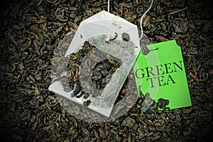 Close-up of a Green tea Bag on many dry leaves - Gunpowder tea