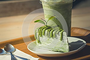 Close up green tea cake and matcha iced green tea on wooden salver.