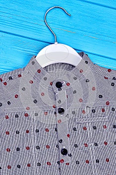 Close up of grey dotted boys shirt.