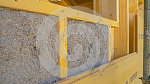 CLOSE UP: Ecofriendly cellulose insulation fills up a frame on a wooden wall. photo