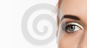 Close-up grey eye with professional makeup looking at the side, on a white background. free space for text