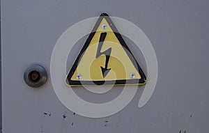 close-up: grey metalic door with caution risk of electric shosk sign