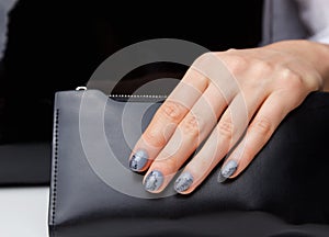 Close-up of grey nails with lace motives photo