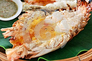 Close-up of grilled giant River Prawn or River Shrimp on the wooden plate with sea foods sauce of Thai style. Foods concept