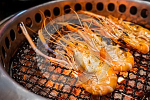 Close up grilled prawns on flaming grill,over charcoal on stove
