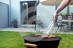 Close up of a grilling beef burger at cozy terrace in summer