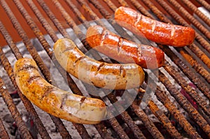 Close up of grilling sausages on barbecue grill. BBQ in the garden. Bavarian sausages