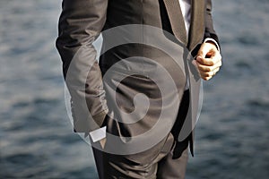 Close-up of groom with hands in pocket, waiting for bride