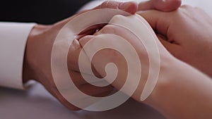 Close-up of groomâ€™s and brideâ€™s hands holding each other Shot on RED Digital Cinema Camera in 4K