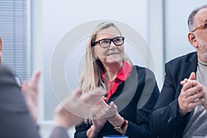 Close up. a group of business people applauding during a working meeting.