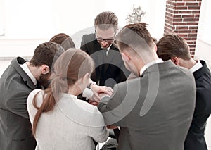 Close up.a group of employees folded their hands together