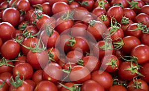 Close up of group of fresh red tomatoes at a farmers market.