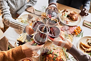 Close up of group of friends toasting with red wine glasses