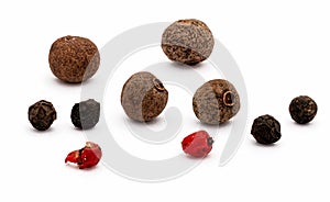 Close-up of group of grains of various types black pepper, pink, green and allspice. Isolated on white background