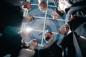 Close up. group of happy young business people standing in a circle.