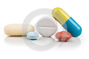 Close-up on group of medicine in capsule, caplet, tablet format on white background
