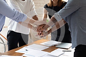 Close up group of multiracial people joining hands together.