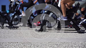 Close up of group of people cycling on machine outdoor. Healthy lifestyle, fitness, cardio concept