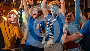 Close Up on a Group of Supportive Soccer Fans with Painted Blue and White Faces Standing in a Bar