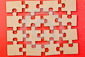 Close up of a group of wooden puzzle pieces on red background