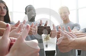 Close up. group of young people showing thumbs up.