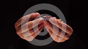 Close-up of a grown man's hands praying and holding a rosary