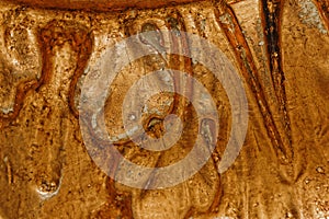 Close up of grunge golden potal texture. Foil on architectural detail. Cracelures and bitumen varnish. Selective macro focus photo