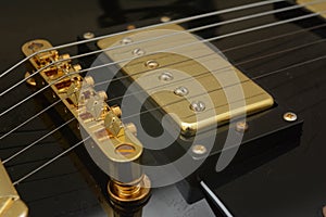 Close up guitar bridge, string and pickups.