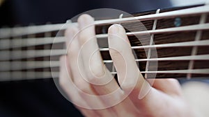 A close-up of the guitarist's fingers rearranging chords on the bass fretboard.