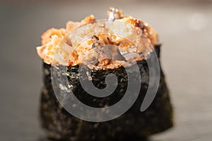 Close up of Gunkan Sushi. Gunkan Maki Sushi with Seafood and Spicy Sauce. Delicious Gunkan Sushi on black background