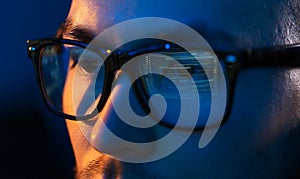 Close up of hacker in glasses looking at screen